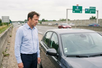 Homme d'&acirc;ge moyen sur l'autoroute regardant son pare-brise fissur&eacute;